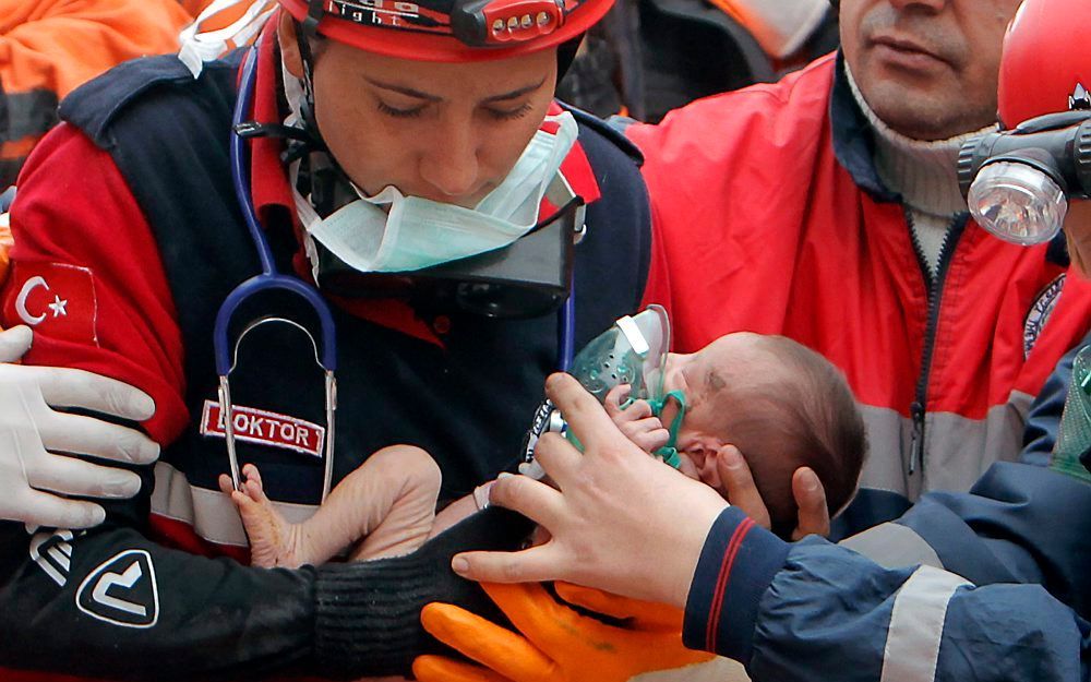 De baby van twee weken oud die onder het puin vandaan gehaald wordt. Foto EPA