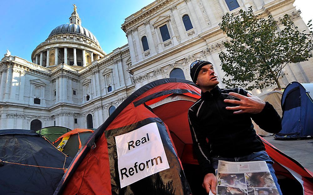 Een Occupy-demonstrant voor St. Paul's Cathedral in Londen. Foto EPA