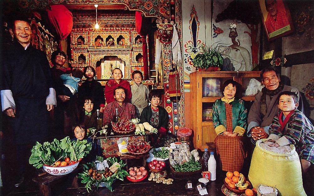 De familie Namgay uit Bhutan voor het huisaltaar.  Foto Peter Mentzel