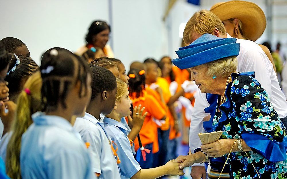 Koningin Beatrix geeft een meisje een hand bij de opening van de nieuwe sporthal bij The Field op Sint Eustatius.  Foto ANP