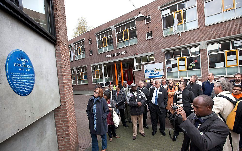 Deelnemers aan een symposium over de Dordtse Kerkorde maakten woensdag een wandeling door Dordrecht. Bij een plaquette over de synode van 1618-1619 hielden ze even halt. Foto Dirk Hol