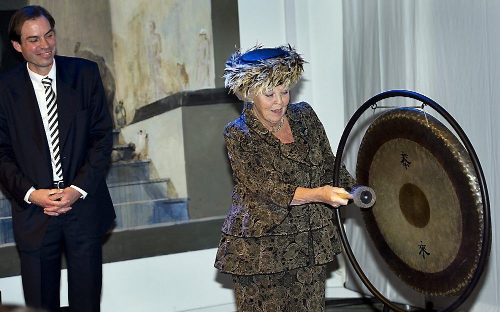 Met een slag op een Chinese gong verricht Koningin Beatrix, met links museumdirecteur Michel van Maarseveen, de heropening van het vernieuwde Drents Museum in Assen. Foto ANP