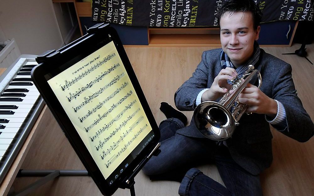 Trompettist Rinse Ringma leest zijn muziek vanaf een Android-tablet op een aangepaste lessenaar. Foto Frans Andringa