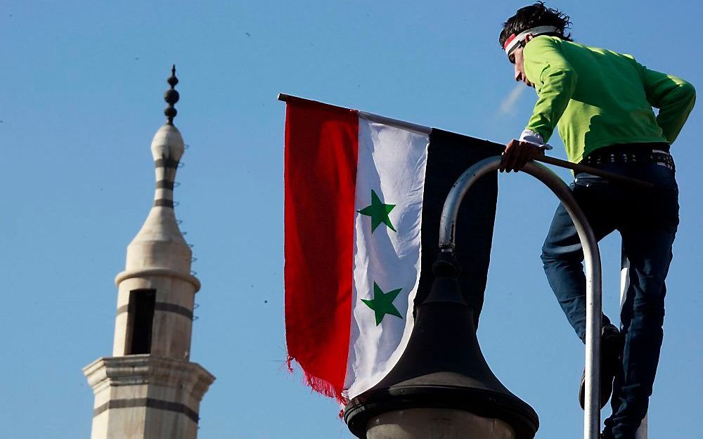 Een Syrische proregeringsbetoger, vrijdag in Damascus. Christenen in het noordoosten van Syrië vrezen de verdwijning van het regime. Ze zijn bang voor Koerdische onderdrukking. Foto EPA