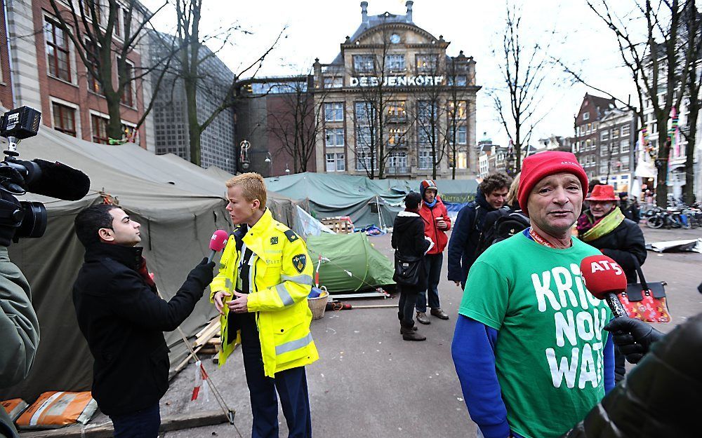 Politieagent en bewoner Beursplein in gesprek met de pers.  Foto ANP