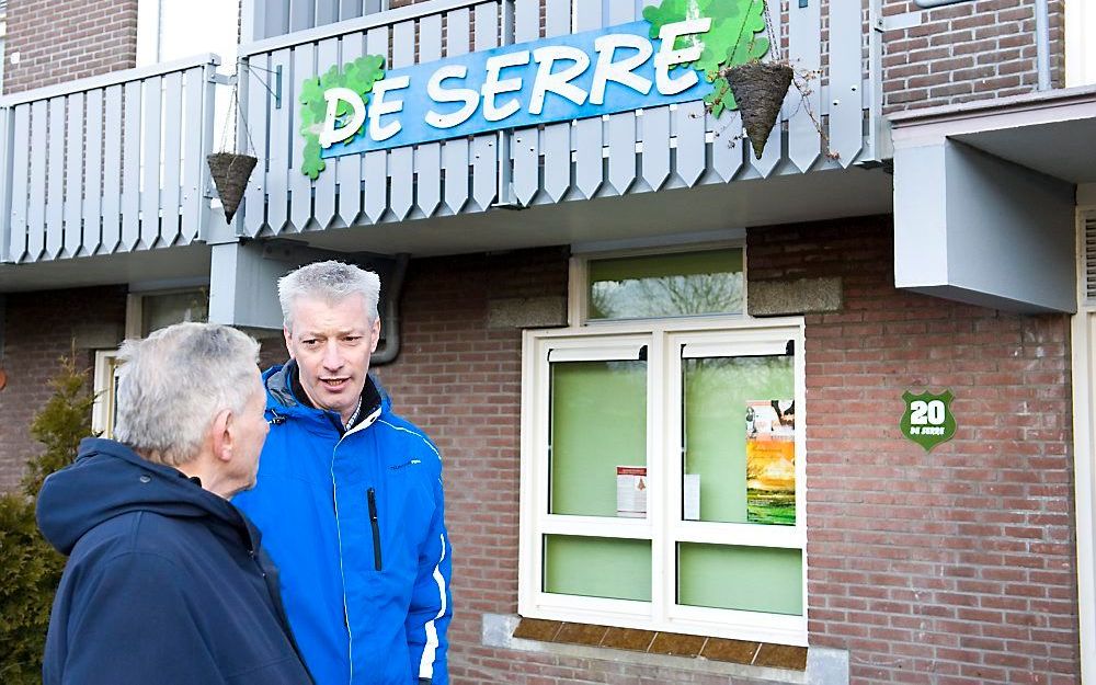 Voorganger André Meulmeester (r.) van christelijke gemeente De Wegwijzer in Almere in gesprek met een bewoner van Almere-Haven, voor het inloophuis dat zijn gemeente vorig jaar in die wijk opende. Foto Arjan Bokhorst