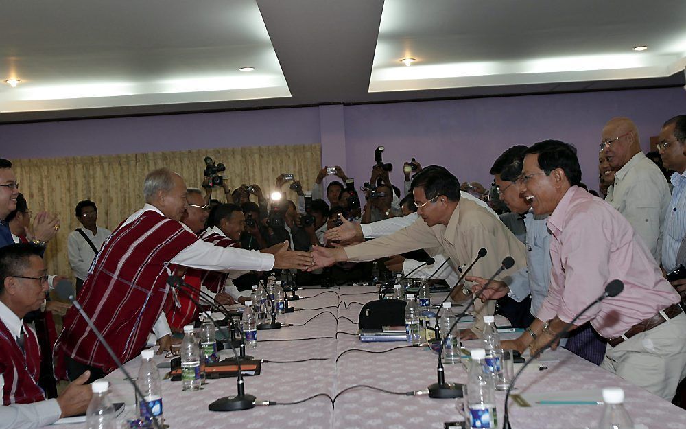 Vertegenwoordigers van de Karen en de regering van Myanmar schudden elkaar de hand. Foto EPA