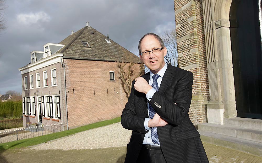 HOORNAAR – Dr. H. Klink, predikant van de hervormde gemeente in Hoornaar, voor het kerkgebouw. Links ervan de pastorie. Foto RD, Anton Dommerholt