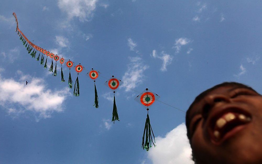 Een Indiase jongen vermaakt zich met z’n vlieger op een festival van Maidan in het oosten van India. Foto EPA