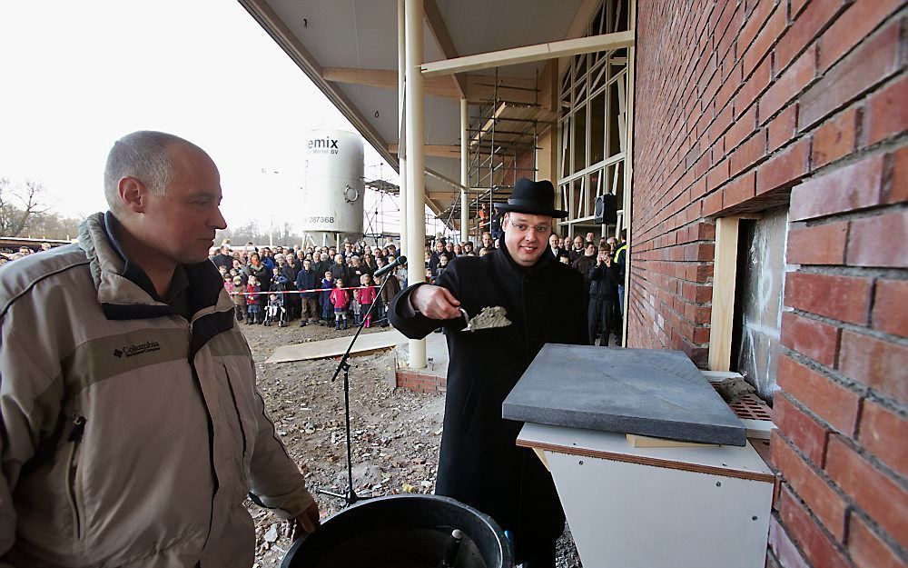 Ds. A. Verschuure maakt zich gereed om de 'eerste steen' van het nieuwe kerkgebouw van de Gereformeerde Gemeente van Scherpenzeel aan te brengen. Foto's Jaco Klamer