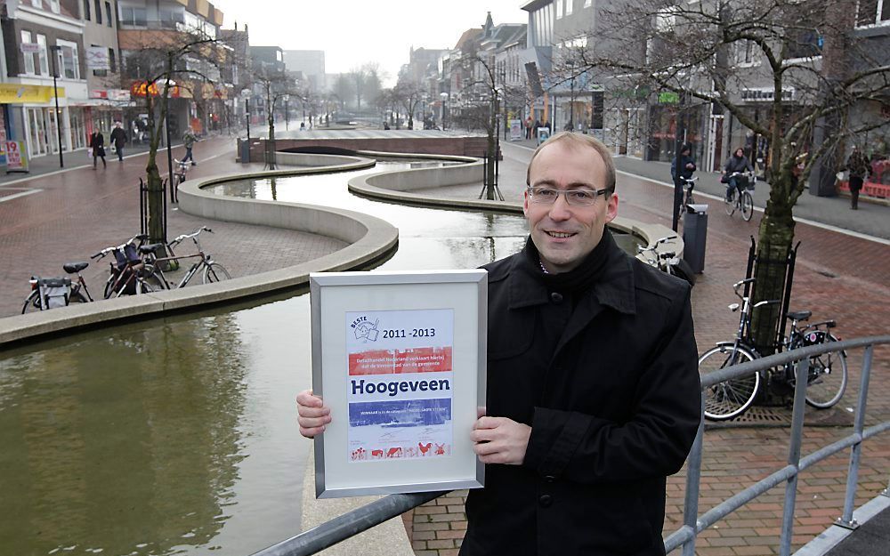 Wethouder Hiemstra van Hoogeveen met de oorkonde voor de Beste Binnenstad van het Jaar. Achter hem de Cascade, het langste waterkunstwerk van Nederland. Foto RD, Anton Dommerholt