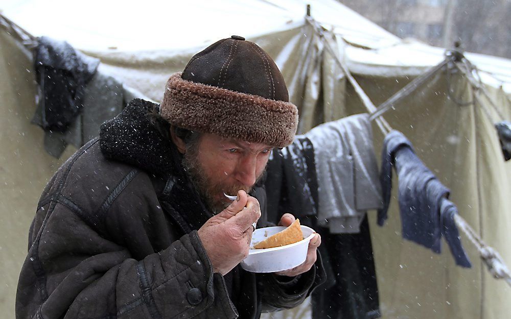 Een dakloze in Donetsk krijgt te eten. Foto EPA