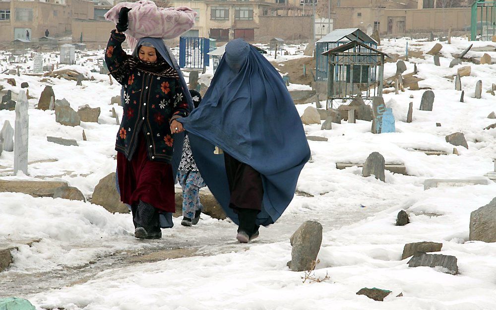 Afghaanse vrouwen op een besneeuwde begraafplaats.  Foto EPA