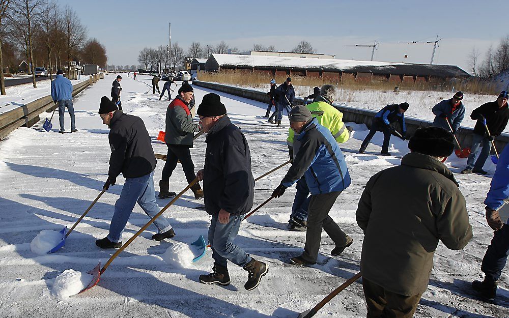 Baanvegers werken maandag met man en macht aan de ijsvloer op de Luts, een van de knelpunten van de Elfstedentocht. Foto ANP