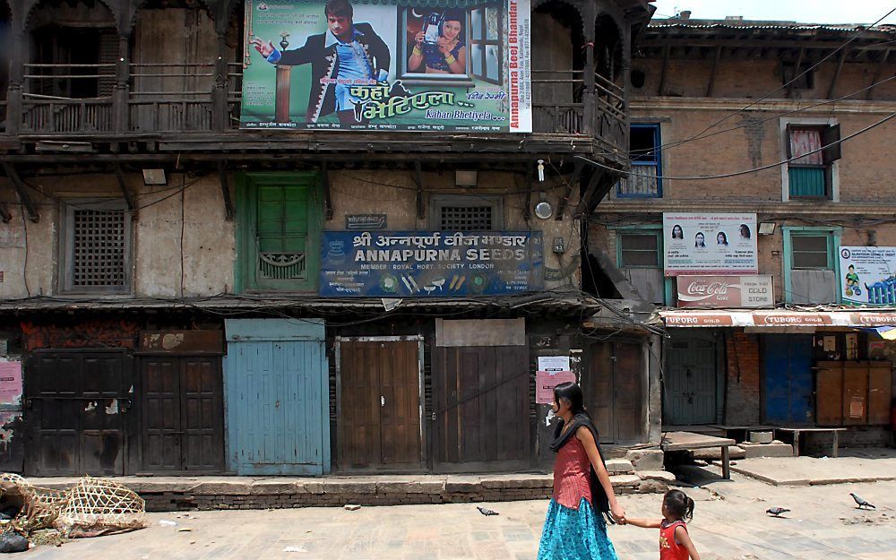 Een moeder in Nepal neemt haar dochtertje aan de hand mee naar huis. Foto EPA