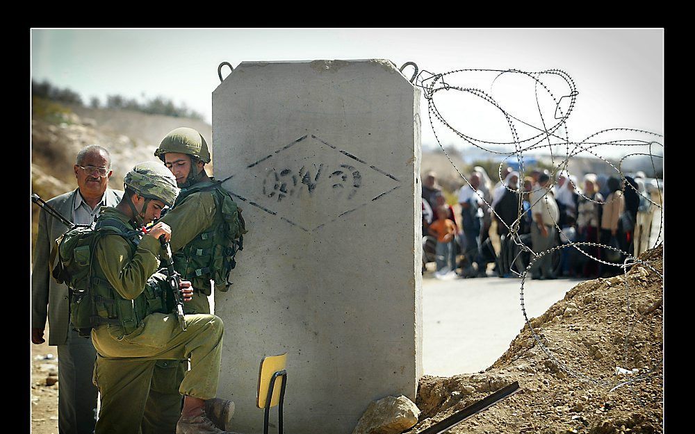 Palestijnen wachten bij een checkpoint in de buurt van Bethlehem totdat Israëlische militairen hen doorlaten. Foto Sjaak Verboom