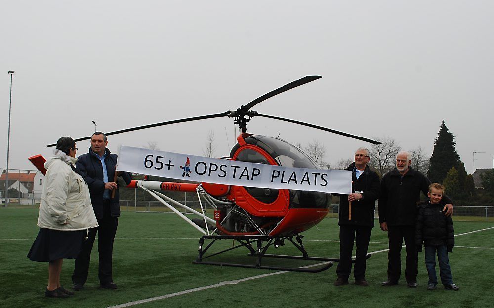 Vrijwilliger Jan Meulmeester (r.) van het Calvijn College Krabbendijke met vrouw, collega’s en kleinzoon na de helikoptervlucht die hij maandag kreeg voor zijn 65e verjaardag. Foto Calvijn College