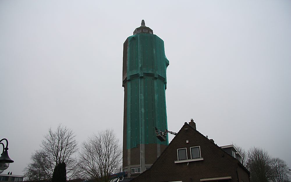 Het bovenste gedeelte van de watertoren van Leerdam is gisteren ingewikkeld in steigerdoek. Foto Jan Willem Versluis