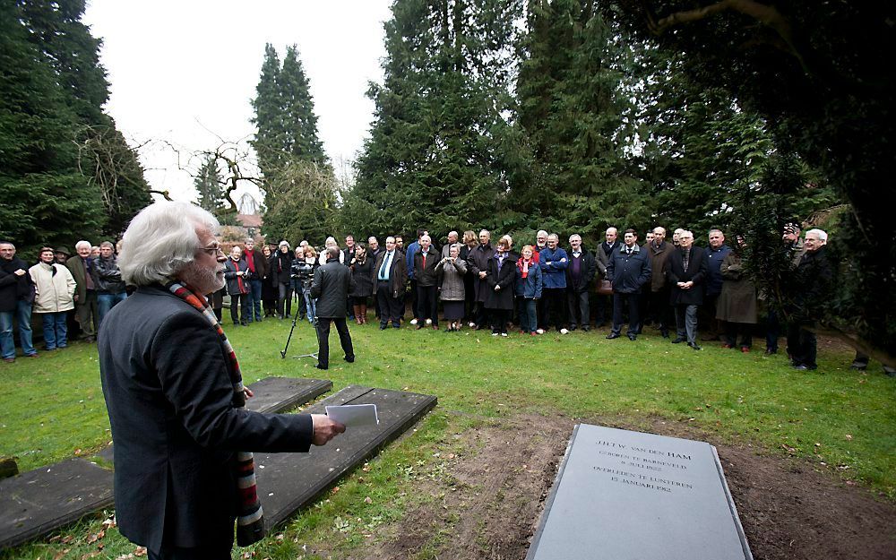 De voorzitter van stichting Het Luntersche Buurtbosch, Ab Welgraven, spreekt belangstellenden toe bij het vernieuwde grafmonument van notaris Van den Ham in Lunteren. Foto Herman Stöver