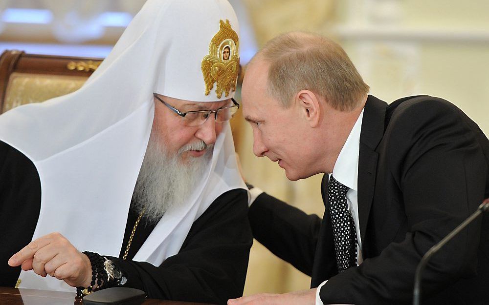 Wat zegt patriarch Kirill (l.) tegen premier Poetin (r.)? Betuigt hij zijn trouw aan het Kremlin? Of heeft hij ongezouten kritiek? De relatie tussen kerk en Kremlin is nauw, maar niemand weet er het fijne van. Foto AFP