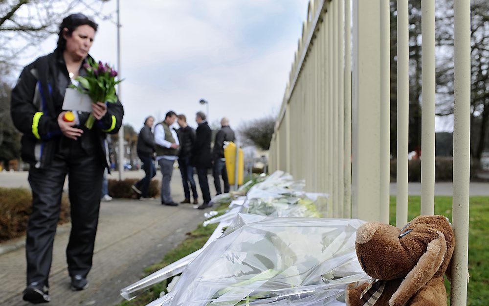 Bij het hek van basisschool 't Stekske in het Belgische Lommel worden bloemen neergelegd. Foto ANP