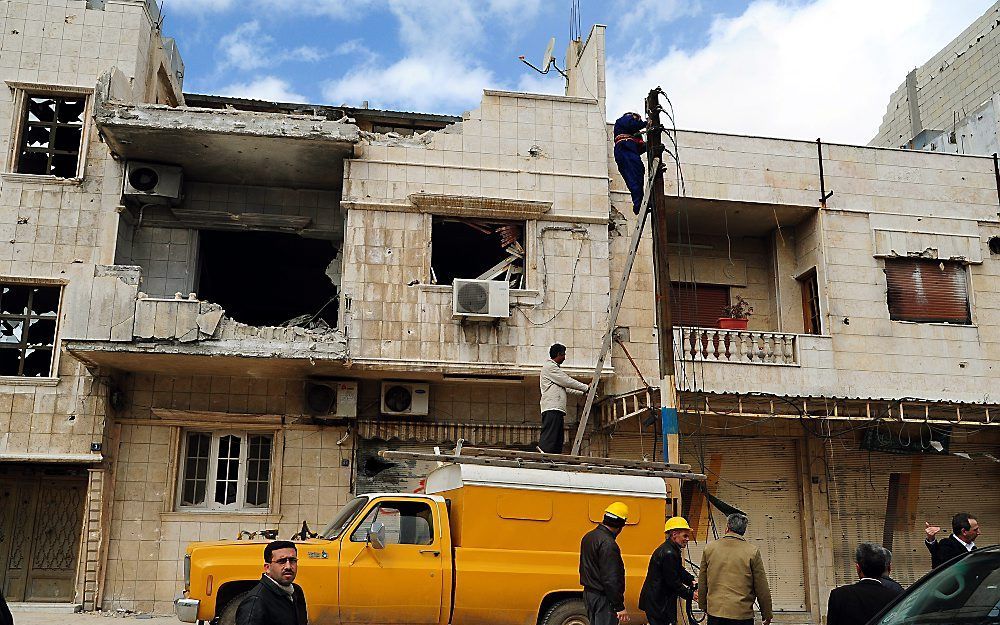 Werknemers repareerden woensdag elektrische leidingen in de wijk Baba Amro in Homs. Bij gevechten met Syrische troepen lieten hier honderden burgers het leven. Foto EPA