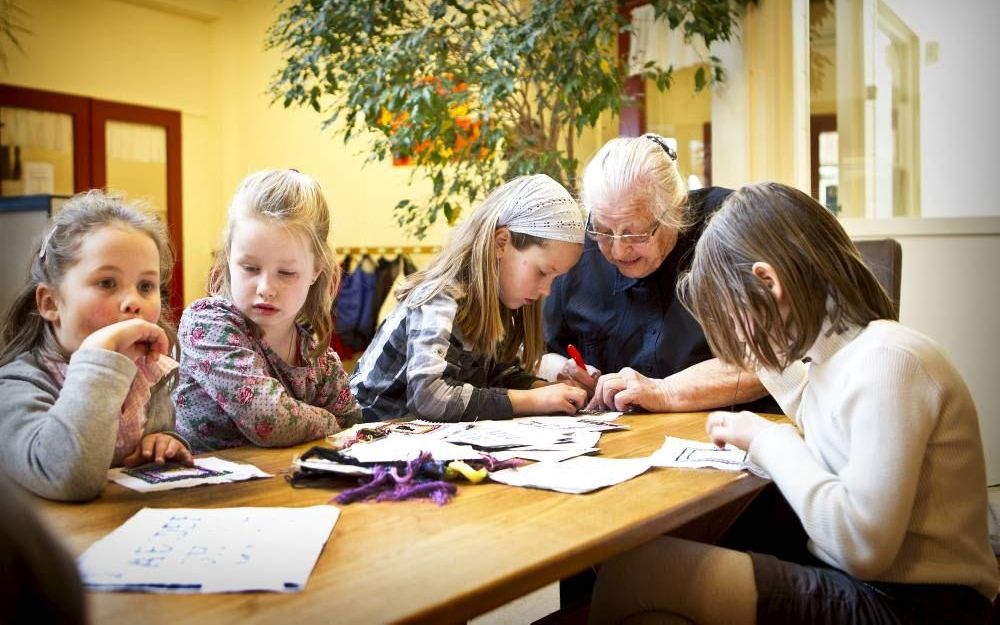 Handwerkjuf Garrigie uit Oldebroek is donderdag 90 jaar geworden. Elke week geeft ze nog handwerken aan de meisjes van groep 4. „Ik vind het leuk om met de kinders bezig te zijn.” Foto RD, Henk Visscher