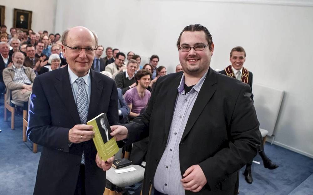 De bundel ”Wie is die man” werd vrijdagavond in Kampen door redactielid Marius van Rijswijk overhandigd aan prof. dr. M. te Velde (l.), rector van de Theologische Universiteit Kampen. Foto Frans Paalman