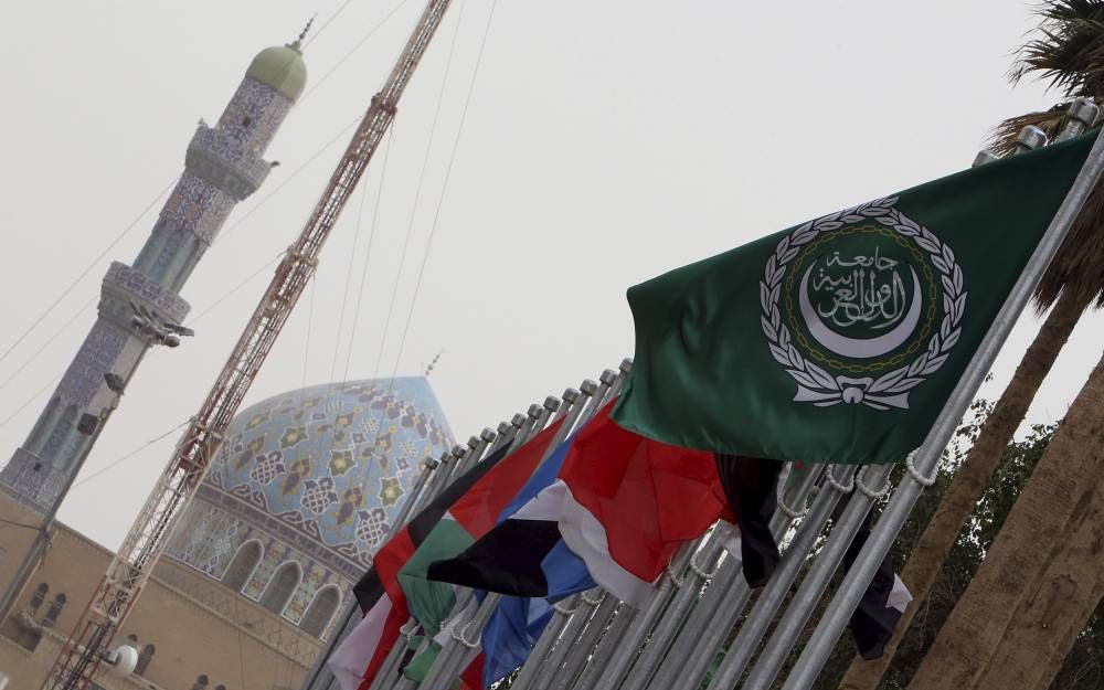 De groene vlag van de Arabische Liga (r.) siert samen met de vlaggen van Arabische landen de straten van de Iraakse hoofdstad Bagdad. Foto EPA