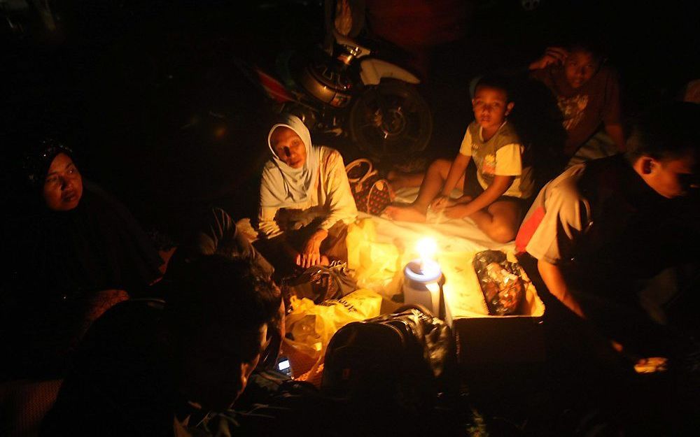 Indonesiërs brengen buiten de nacht door, uit angst voor naschokken. Foto EPA