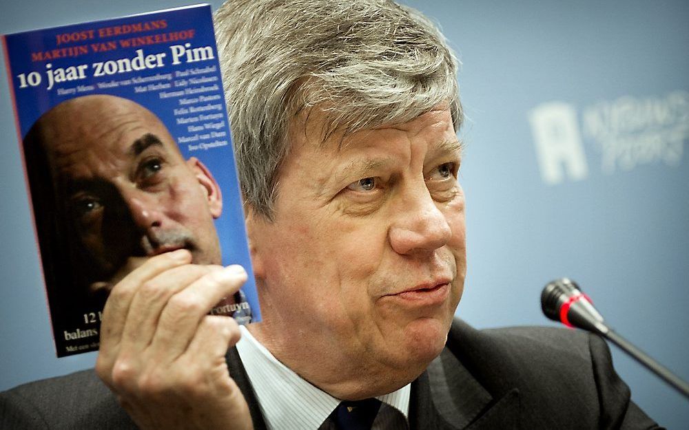 Minister Opstelten neemt het boek '10 jaar zonder Pim' in ontvangst.  Foto ANP