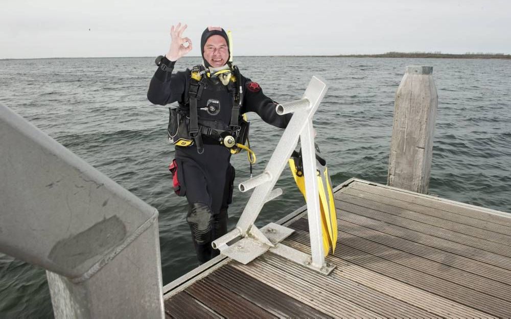 Wie gaat duiken, moet eerst een aantal gebaren leren om onder water met andere duikers te kunnen communiceren. Instructeur Teun Schoenmaker van Duikcentrum de Grevelingen gebaart dat „alles oké” is bij duikstek Nieuwe Kerkweg. Foto Wim van Vossen