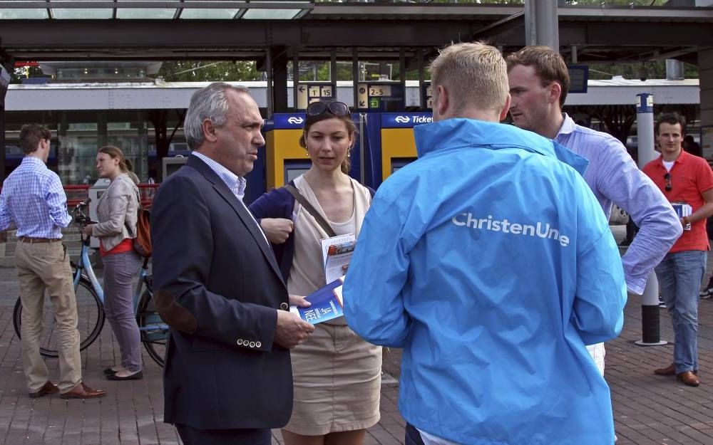 CU- en SGP-jongeren voerden gisteren in Dordrecht samen met CU-lijsttrekker Van Dalen (l.) campagne voor de Europese verkiezingen. Ze wezen via ansichtkaarten op de 270.000 gevallen van gedwongen prostitutie in de EU. Europese samenwerking tegen mensenhan