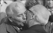 Het was feest en daar hoorde een kus bij. Zo ook bij de ontvangst van Gorbatsjov (l.) bij het jubileumfeest van de DDR. Maar toen Honecker (r.) twee weken later moest aftreden, steunde Gorbatsjov hem niet. Foto AFP