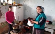 Vera en haar dochter uit Sjevshenkovo in Oekraïne bereiden een maaltijd. Het gezin met vijf kinderen moet rondkomen van ongeveer 50 euro per maand. Foto KOEH