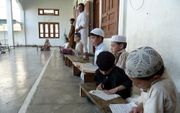 Pakistaanse kinderen leren Koranteksten uit hun hoofd op een madrassa. Deze schooltjes zijn kweekvijvers voor haat tegen christenen in hun land. Foto EPA