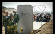Palestijnen wachten bij een checkpoint in de buurt van Bethlehem totdat Israëlische militairen hen doorlaten. Foto Sjaak Verboom