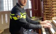 Nieuwkoop speelt in uniform op het orgel van de Laurenskerk in Rotterdam. beeld via Twitter