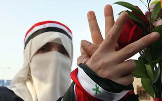 Een Syrische betoger maakt het V-teken tijdens een protest tegen de Syrische president Al-Assad. Foto EPA