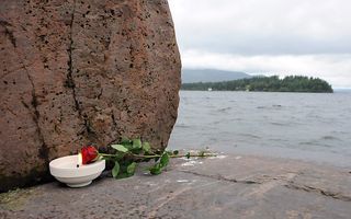 Bloemen voor de slachtoffers van de aanslag. Op de achtergrond het eiland Utoya. Foto EPA