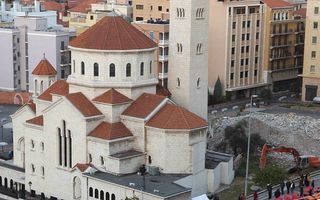 Demonstranten passeren een Armeens-apostolische kerk in Beiroet, tijdens een van de vele protest­manifestaties die Libanon de achterliggende jaren heeft gekend. Veel van deze protesten verlopen langs de strakke religieuze scheidslijnen waardoor het land w