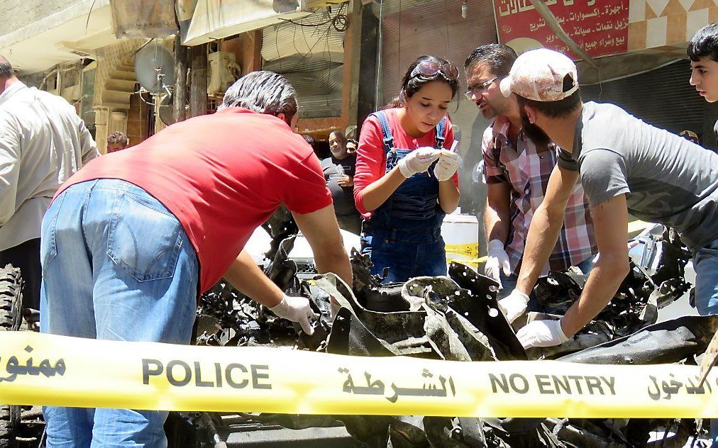 De Syrische politie op de plaats van de aanslag in een voorstad van Damascus. beeld AFP