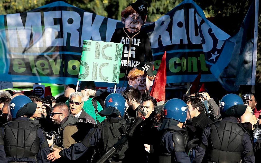 Portugese betogers protesteren tegen het bezoek van Merkel aan Lissabon.  Foto EPA