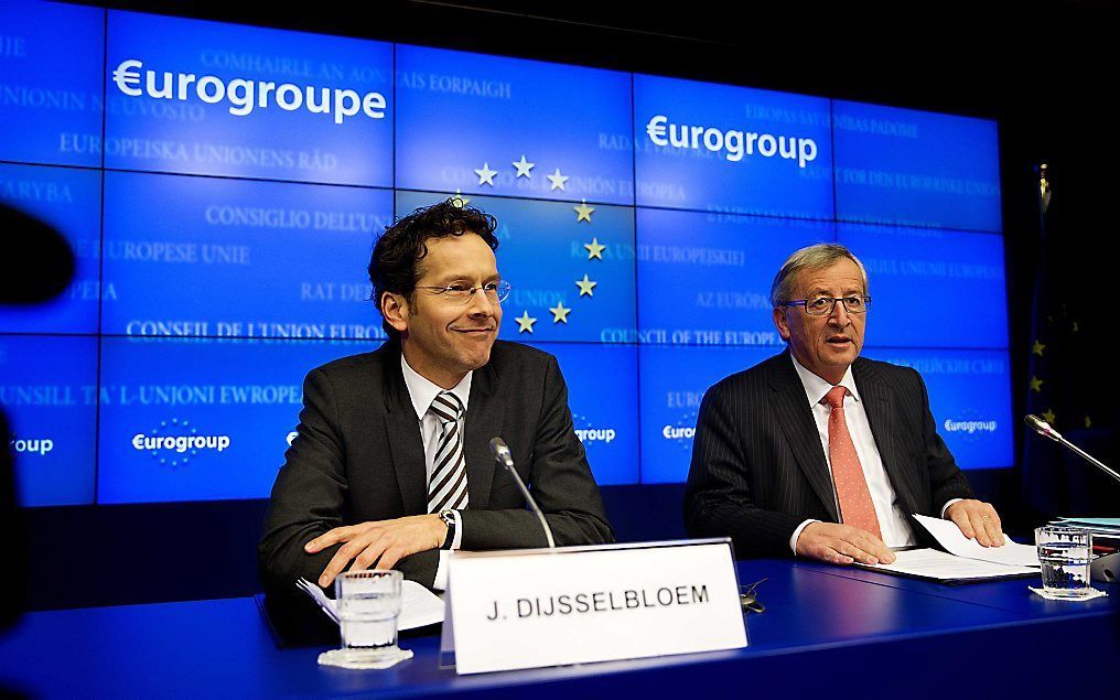 Minister Jeroen Dijsselbloem (L) tijdens de persconferentie na de bijeenkomst van de zeventien ministers van Financien van de EU. Dijsselbloem werd op deze bijeenkomst gekozen tot nieuwe voorzitter van de Eurogroep. Rechts scheidend voorzitter Jean-Claude