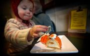 Bezoekers bij bakkerij Schuurmans eten oranje Abdicatiegebak na de aankondiging van de troonsafstand van koningin Beatrix. Foto ANP