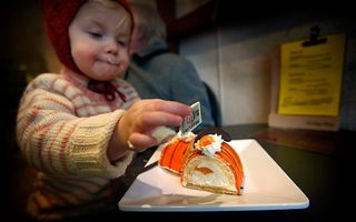 Bezoekers bij bakkerij Schuurmans eten oranje Abdicatiegebak na de aankondiging van de troonsafstand van koningin Beatrix. Foto ANP