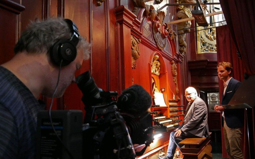 Bij de speeltafel van het Müllerorgel in Haarlem (v.l.n.r.): Sander Klugt (regisseur), Jos van der Kooy (organist) en Sander Zwiep (presentator). beeld Jan Smelik