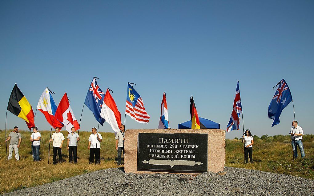 Mensen houden de vlaggen van de landen omhoog waarin mensen zijn omgekomen tijdens de MH17-ramp. Zondag was het twee jaar geleden dat het vliegtuig neerstortte. beeld EPA