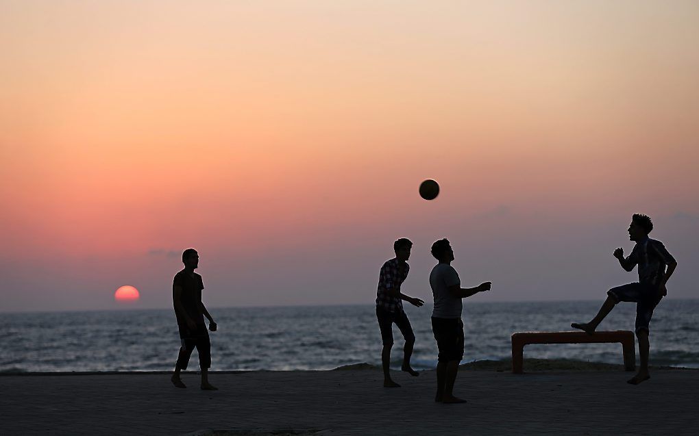 Jongens voetballen op het strand van Gaza. beeld EPA