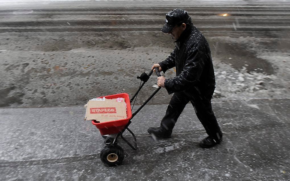 Inwoner van New York strooit zout.  Foto EPA